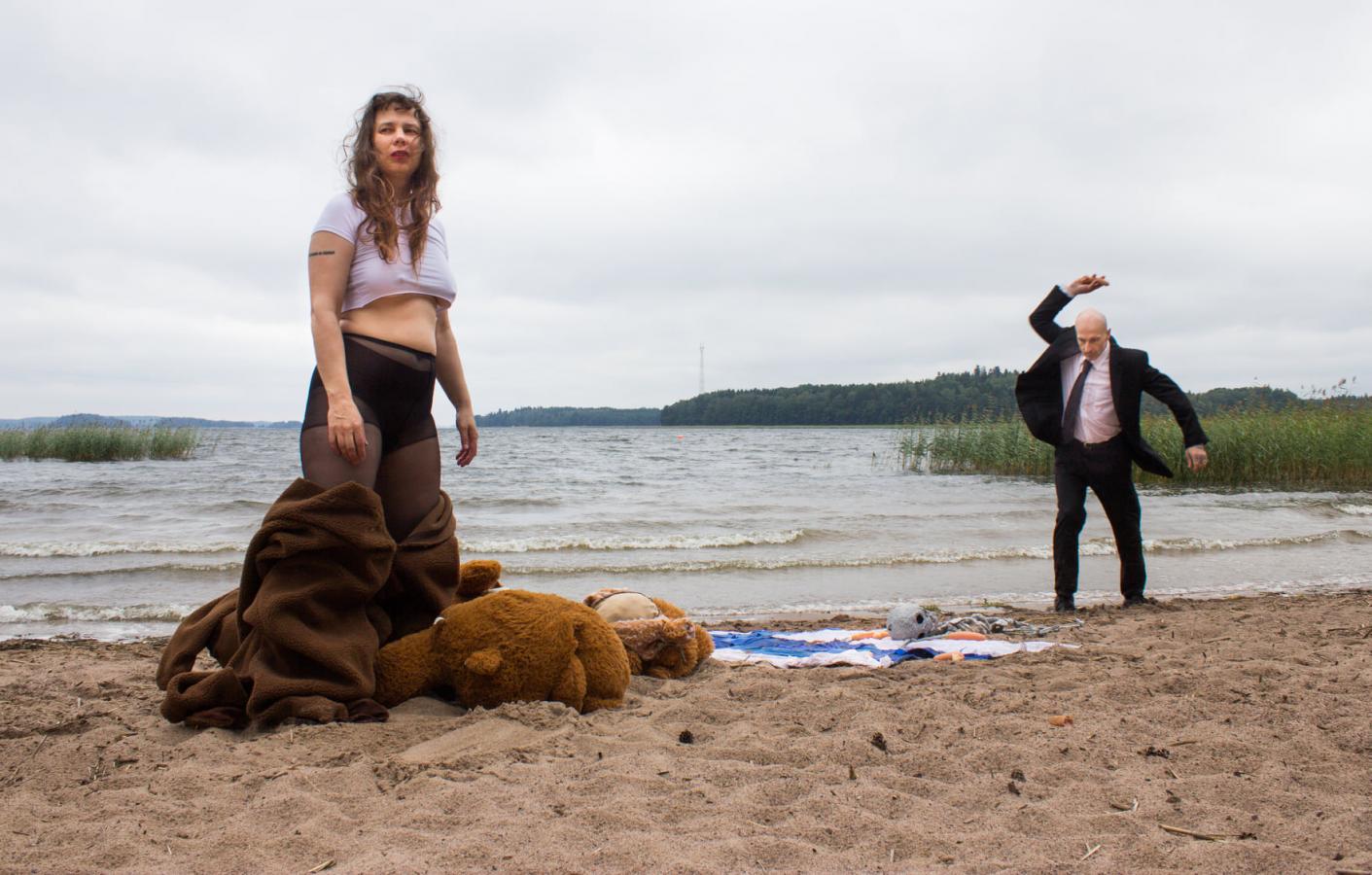 Performanssitaiteilijat Katri Kainulainen ja Maximilian Latva seisovat hiekkarannalla.