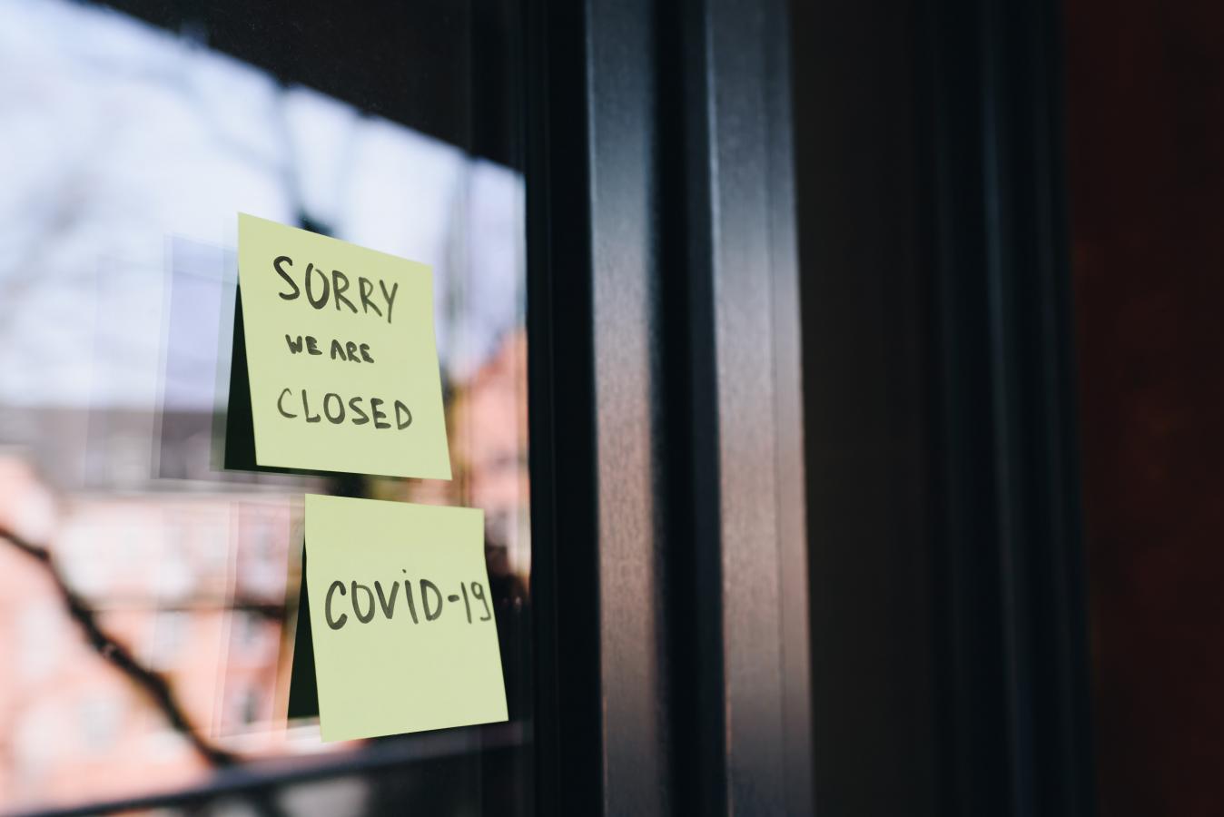 A note on the door that says: Sorry, we are closed. Covid-19. 