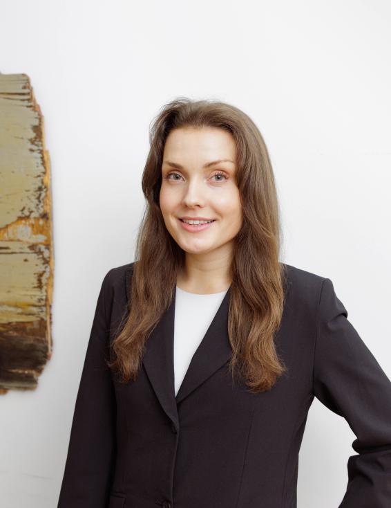 Briitta Kuokkasen kuva. Briittalla on pitkät ruskeat hiukset ja hän on pukeutunut mustaan jakkuun.